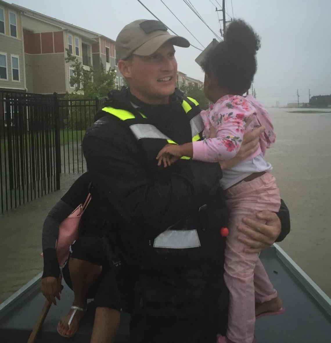 Denton County game warden Josh Bulger helps a young girl onto a boat during a water rescue from an apartment complex in Richmond Monday.