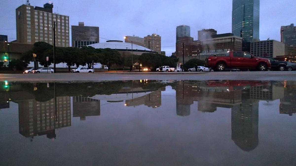 Downtown is reflected in a puddle on Calhoun Street on Oct. 24.