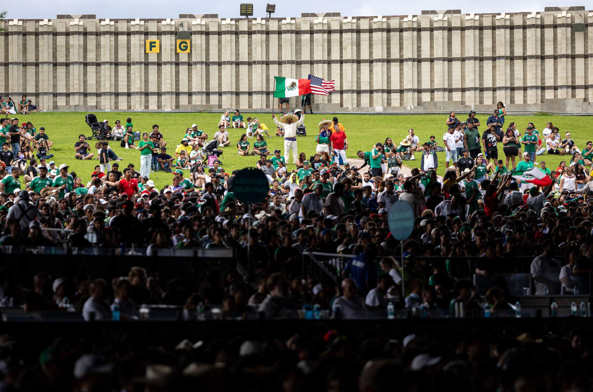 Tiskani Perez holds U.S. and Mexican flags during the FIFA Fan Festival on Thursday, June 11, 2026, at Fair Park in Dallas. Perez brought his son along so that the two of them could watch the game together.