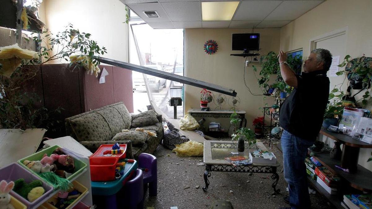 Cleanup contractor Larry Lopez takes a photo of damage caused by a hail storm in west Fort Worth on March 17.