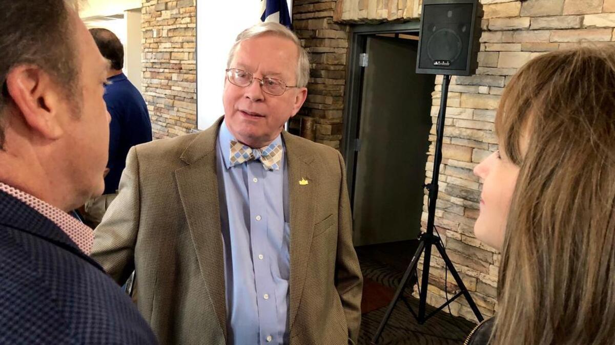 Tarrant County Tax Assessor-Collector Ron Wright, center, talks with school board President Aaron Reich, left.