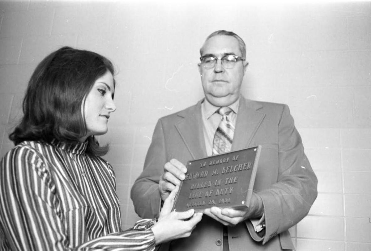In 1972, police Chief T.S. Walls gives Mary Belcher a memorial plaque for her late husband, patrol officer Edward Belcher.