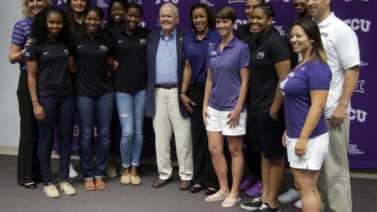 
Ed Schollmaier poses with members of the women’s basketball team following Thursday’s press conference to announce the new name of the basketball arena.
