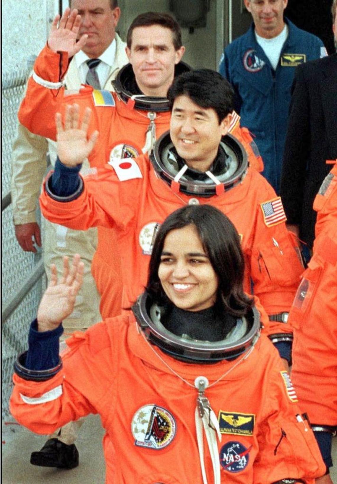 Indian-American astronaut Kalpana Chawla (foreground), Japanese astronaut Takao Doi (C), representing the Japanese National Space Development Agency (NASDA), and Ukrainian astronaut Leonid Kadenyuk (background), wave to journalists as they leave the crew headquarters, at Kennedy Space Center, 19 November, hours before they are scheduled to blast off into space. The space shuttle Columbia crew will perform several microgravity experiments, deploy a satellite and carry out several space walks during their planned 16-day mission.