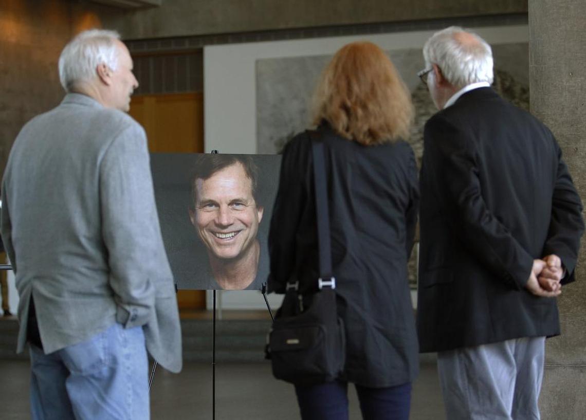 Guests visit around a portrait of Bill Paxton at a tribute in the Modern Art Museum of Fort Worth.