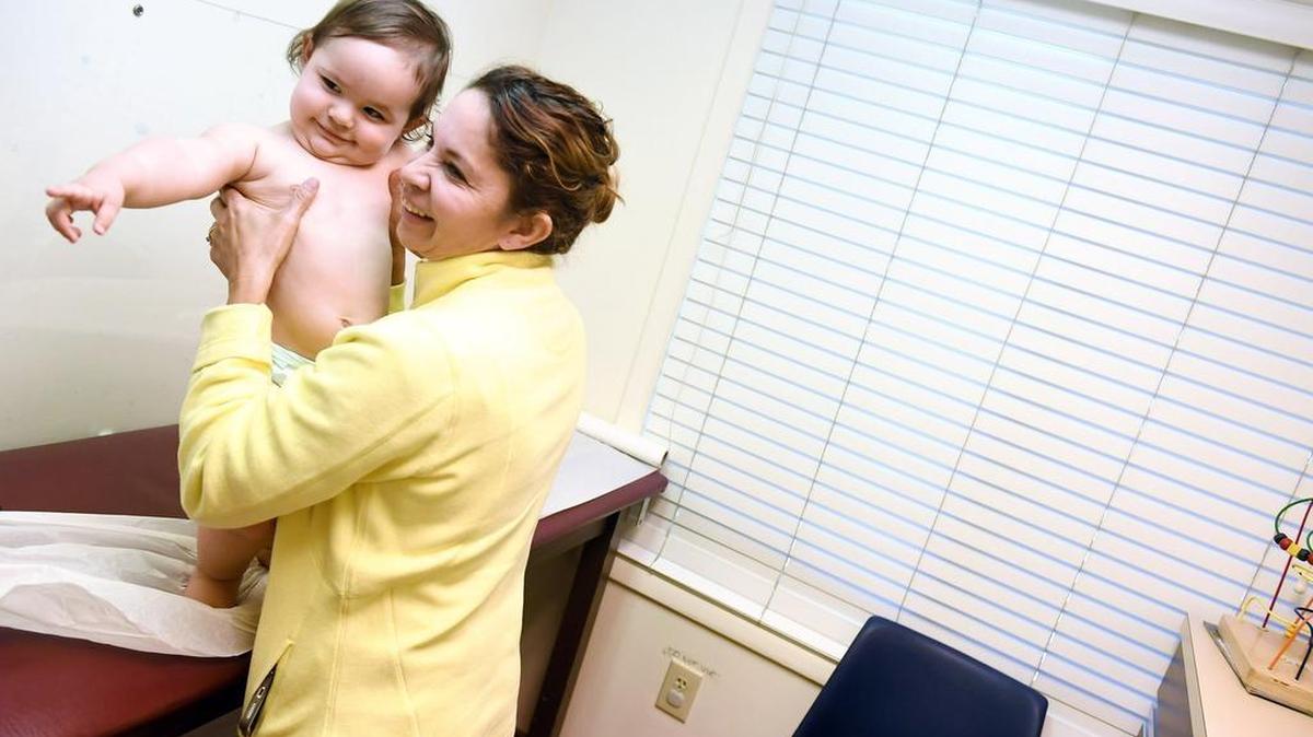 In Virginia, Marbell Castillo holds her granddaughter, Maia Powell, during a recent checkup. Virginia is among states hoping Congress refunds the Children’s Health Insurance Program.