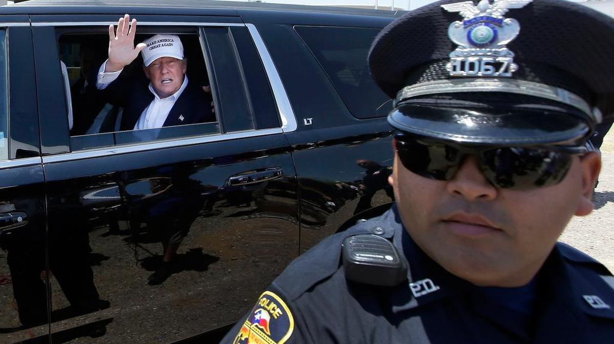 Donald Trump waves passing a Laredo police officer during a tour of the World Trade Interational Bridge.