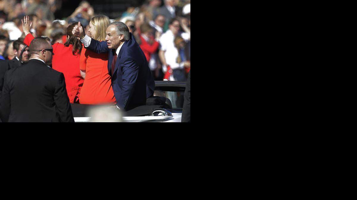 
Texas Gov. Greg Abbott, right, gestures during the parade Tuesday.
