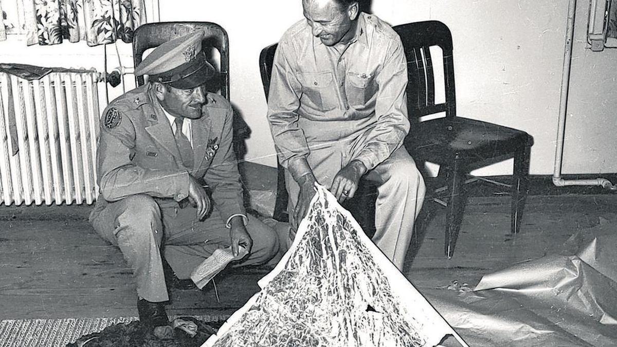 Brig. Gen. Roger Ramey, 8th Air Force commander, left, and Col. Thomas J. Dubose, chief of staff, look over debris flown to Fort Worth Army Air Field (now Naval Air Station Fort Worth) from a mysterious crash near Corona, N.M., in July 1947. The telegram in Ramey’s hand is being studied.