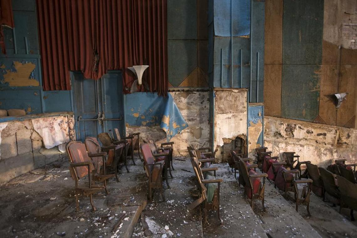 Theater seats and curtain remnants show deterioration after being exposed to the elements for decades.