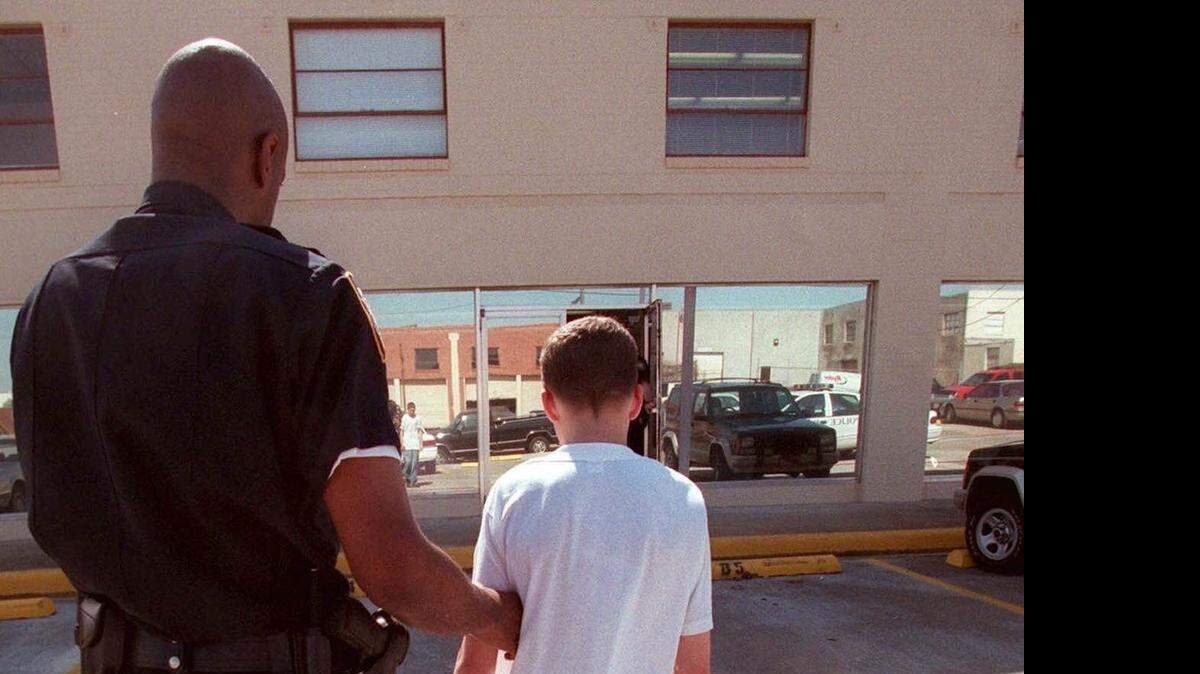 
A Fort Worth police officer escorts a 14-year-old to an attendance hearing.
