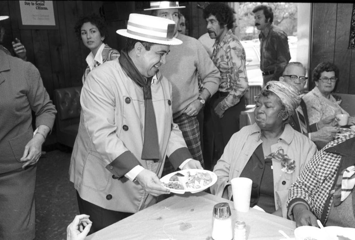 Raul Jimenez serves Thanksgiving dinner to Georgia Benton at Jimenez Restaurant in 1976.