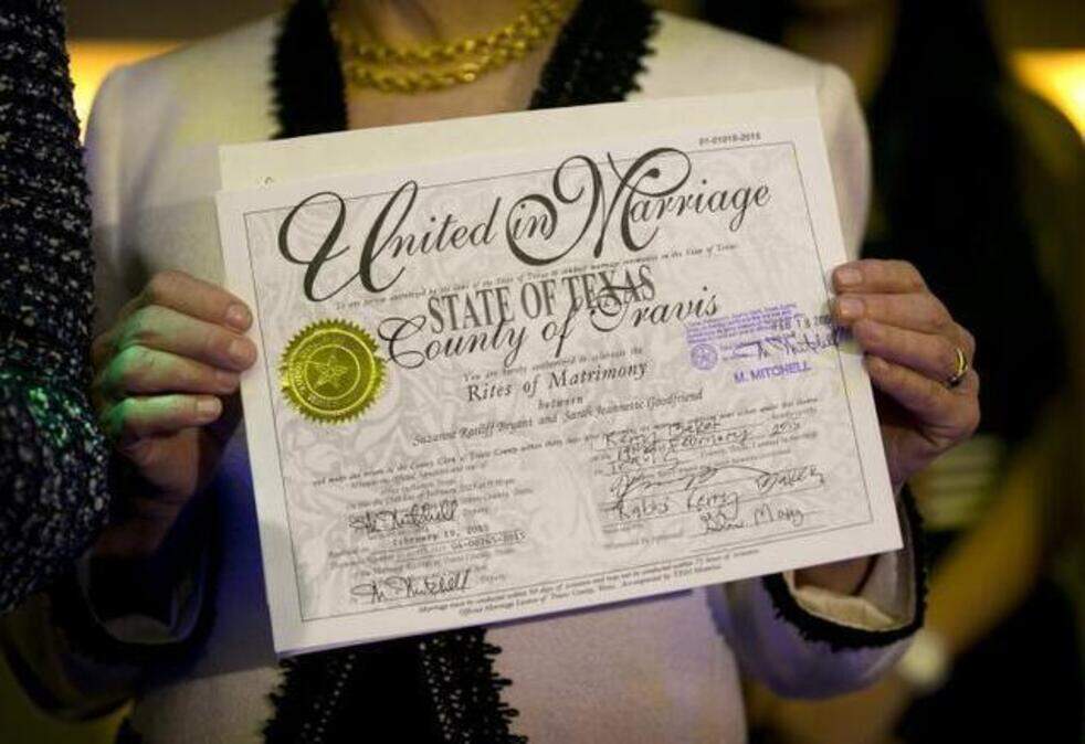 
Suzanne Bryant shows her marriage license at Highland Lounge in Austin after she and her partner, Sarah Goodfriend, became the first legally married gay couple in Texas.
