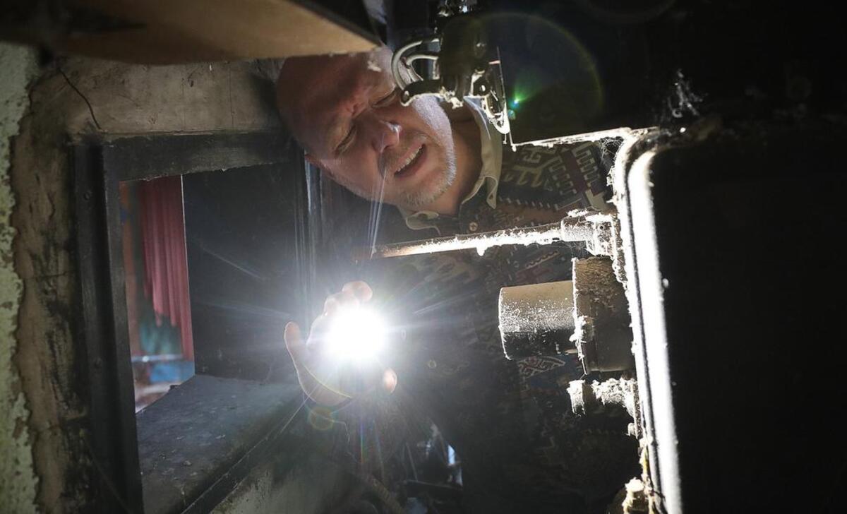 New owner Jeffrey S. Smith looks at the lens on one of the two carbon-arc projectors in 2017.