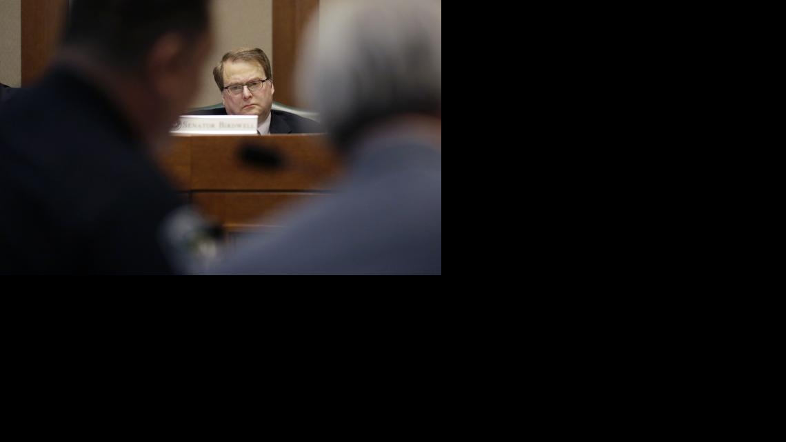 Texas Sen. Brian Birdwell, R-Granbury, listens to Austin police chief Art Acevedo give testimony during a hearing where lawmakers discussed whether to legalize concealed handguns on college campuses and open carry everywhere else, Thursday, Feb. 12, in Austin, Texas. (AP Photo/Eric Gay)
