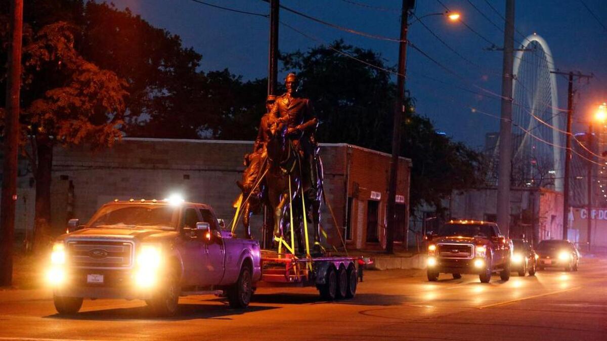 The Robert E. Lee statue is given a police escort after its removal from a public park in Dallas, Thursday, Sept. 14, 2017. In an unannounced move, a large crane was brought through the city by a police escort to Lee Park, where it lifted the large statue from its pedestal late Thursday afternoon.
