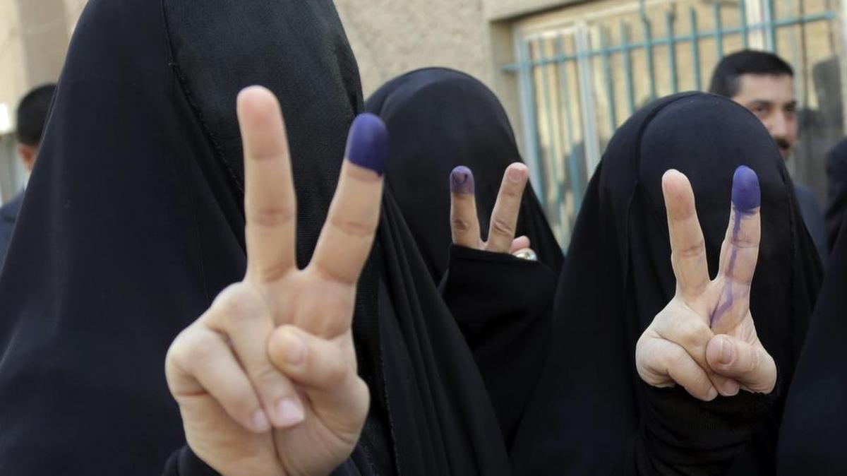 Veiled Iraqi women make victory signs with inked fingers in 2014 after casting votes at a polling center in Baghdad.