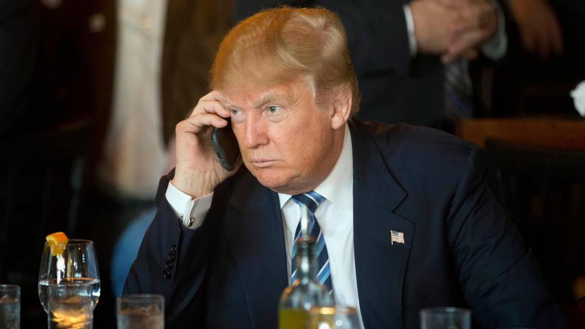 Republican presidential candidate Donald Trump listens to his mobile phone during a stop in South Carolina.