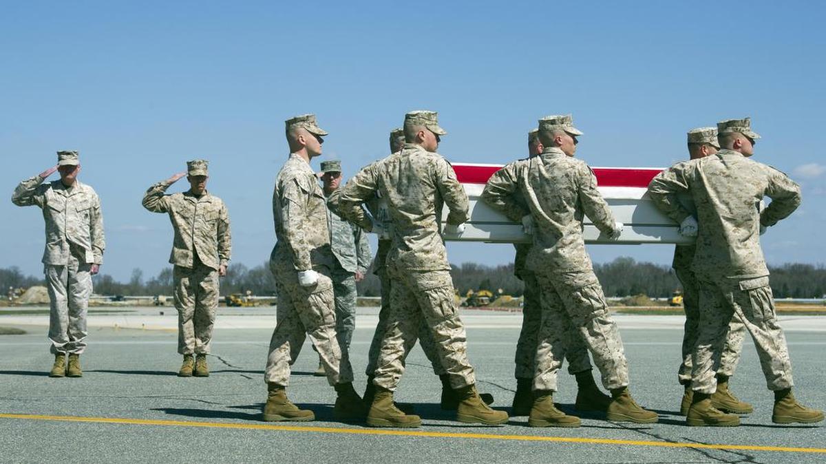 Marines carry a transfer case with the remains of Marine Staff Sgt. Louis Cardin March 21 at Dover Air Force Base, Del.