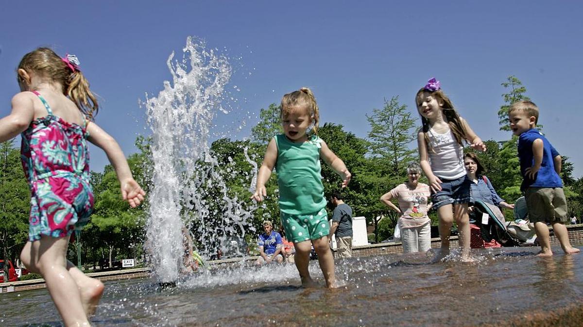 Children play in a fountain, a simple thing that also promotes learning.