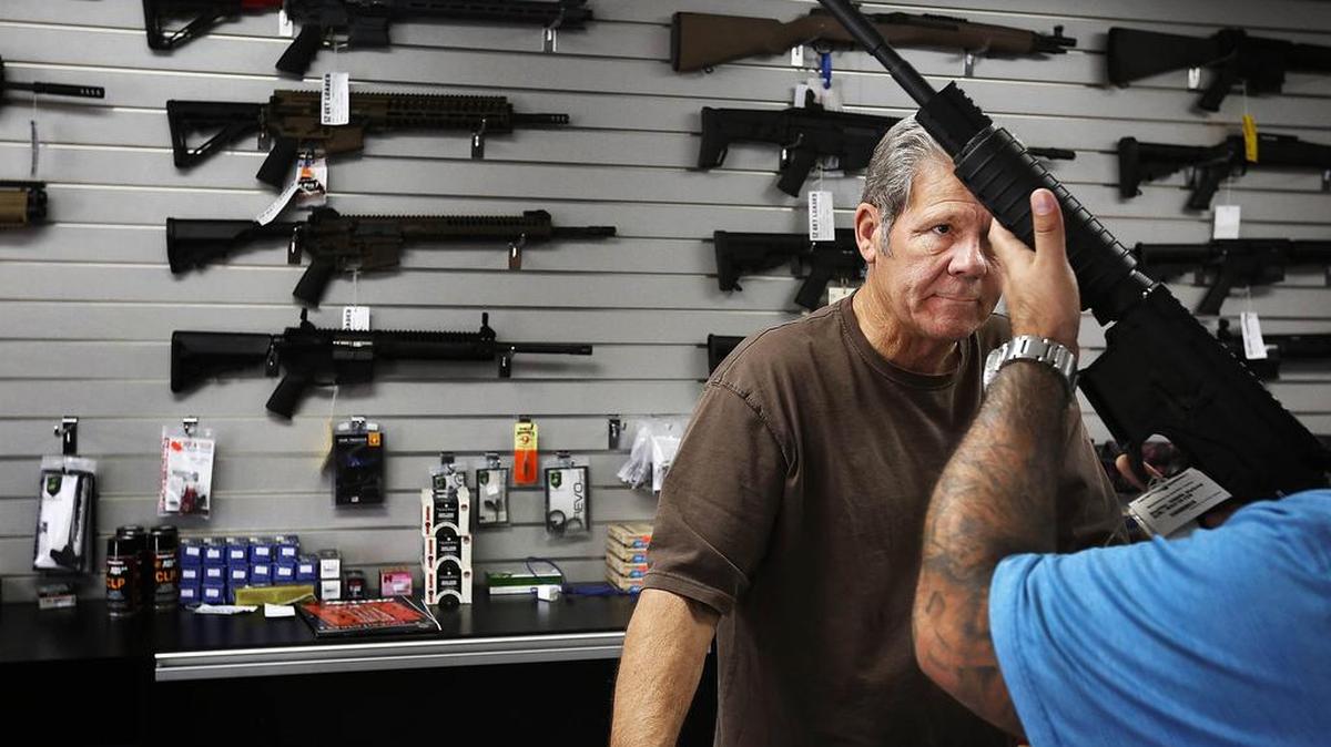 Gunsmith Frank Cobet of the Get Loaded gun store in Chino, Calif., shows a customer an AR-15 rifle.