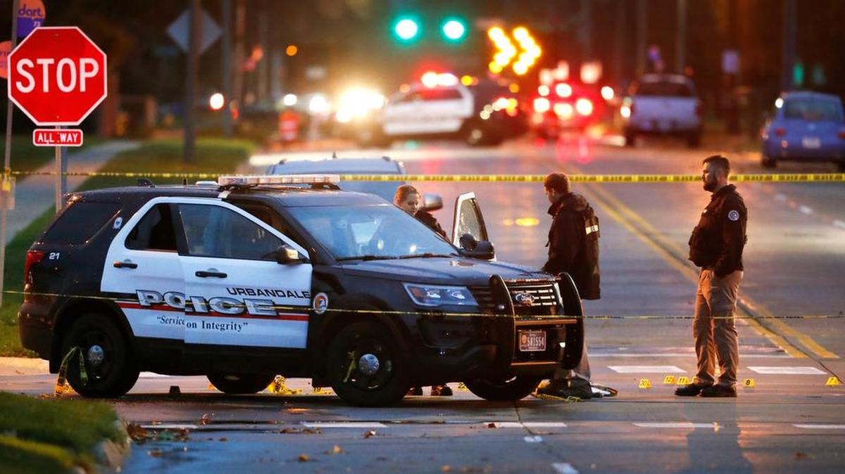 Law enforcement officials investigate at the scene of a shooting, Wednesday, Nov. 2, 2016, in Urbandale, Iowa. Authorities apprehended a man Wednesday suspected in the early morning killings of two Des Moines area police officers who were shot to death while sitting in their patrol cars in what authorities described as separate ambush-style attacks.