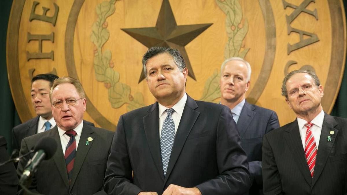 State Rep. Richard Peña Raymond, D-Laredo, center, speaks Monday about improving the foster care system.