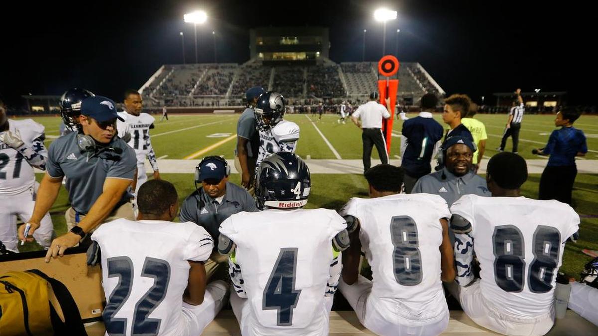 Young Men's Leadership Academy coaches exhort and instruct their players during their Aug. 26 game with Chisholm Trail High School.