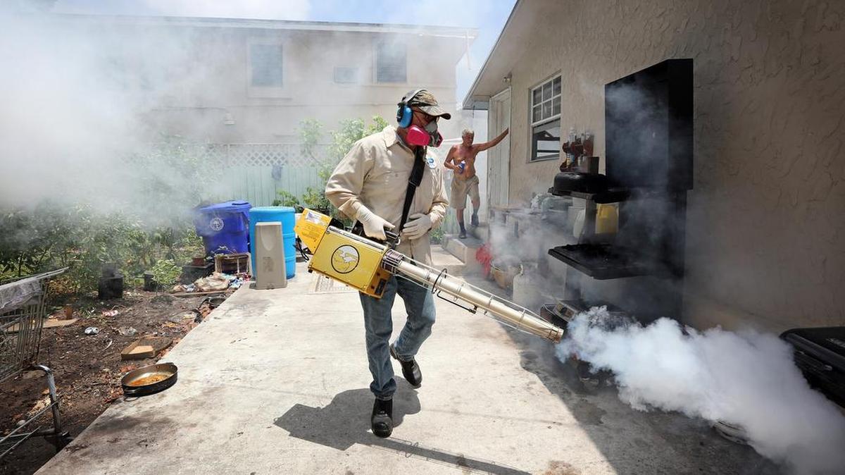 Carlos Varas, a Miami-Dade County mosquito inspector, sprays around homes in the Wynwood area of Miami on Tuesday, Aug. 2, 2016, as 14 cases of Zika have been found in the area.