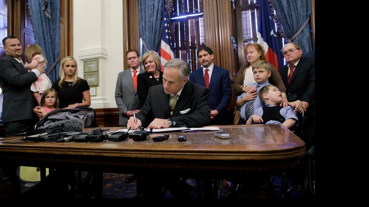 
Texas Gov. Greg Abbott signs a bill allowing the medical use of low-THC cannabis into law on Monday. 
