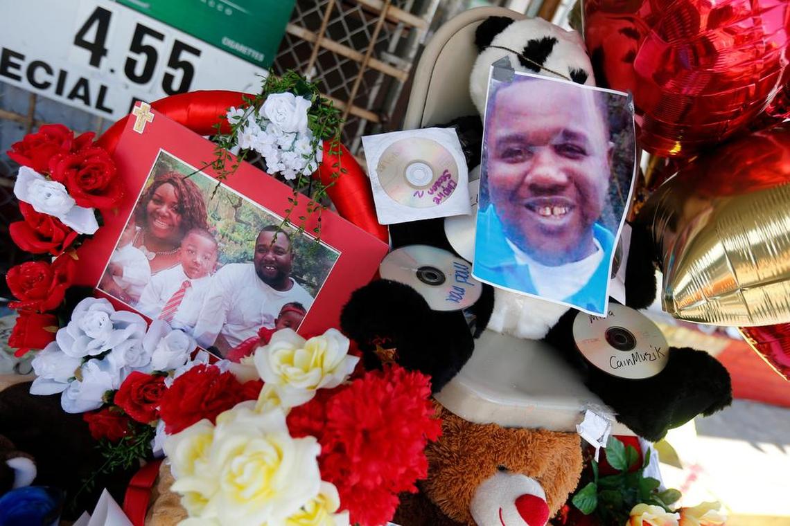 Photos of Alton Sterling are interspersed with flowers and mementos at a makeshift memorial in front of the Triple S Food Mart in Baton Rouge, La., Thursday, July 7, 2016. Sterling, 37, was shot and killed outside the convenience store by Baton Rouge police, where he was selling CDs.