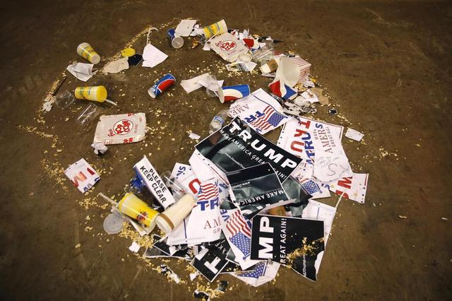 Trash is rounded up, including torn campaign signs for Republican presidential candidate Donald Trump, after a rally for Trump was canceled due to security concerns, on the campus of the University of Illinois-Chicago, Friday, March 11, 2016, in Chicago.