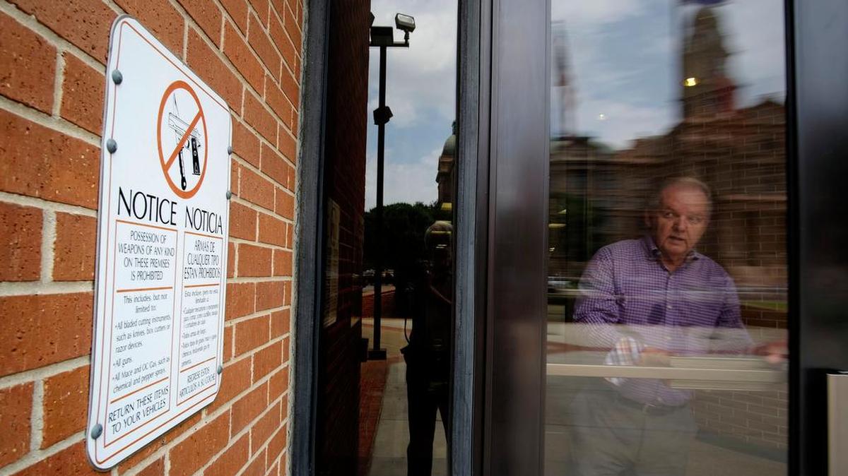 Signs at door of the Tarrant County Administration Building warn visitors that weapons are not allowed.