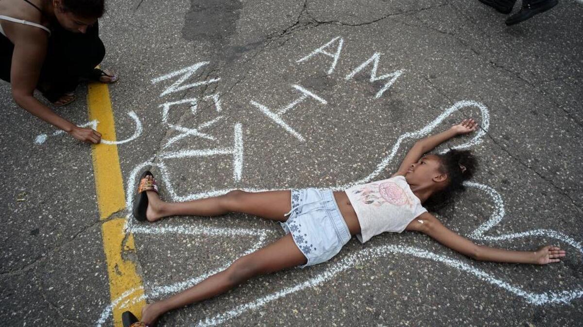 Tia Williams, left, and her daughter Aissa create a display on the street outside the Minnesota governor's official residence Thursday, July 7, 2016, in St. Paul, Minn., as people gathered to protest the shooting death of Philando Castile by police.