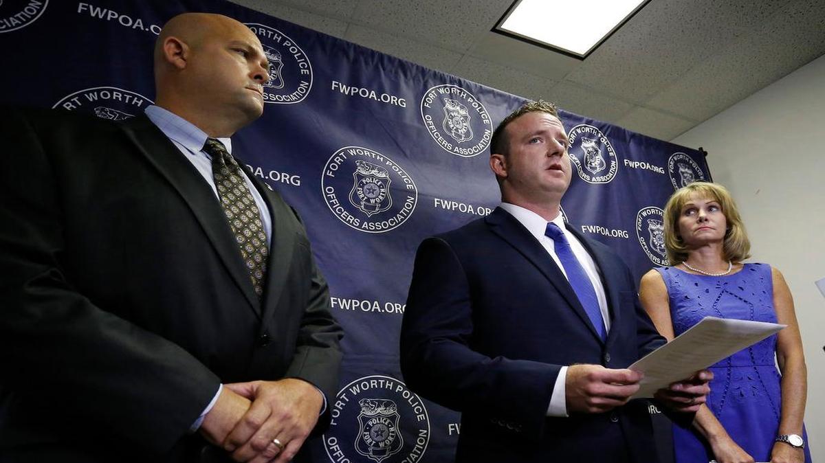 Officer Courtney Johnson (c), with FWPOA Pres. Sgt. Rick Van Houten (l) and CLEAT lawyer Terry Daffron (r), reads a statement during the conference. The Fort Worth Police Association held a press conference to discuss officer Courtney Johnson's firing by Chief Joel Fitzgerald, and low confidence in the chief by his officers, Thursday, July 12, 2017.
