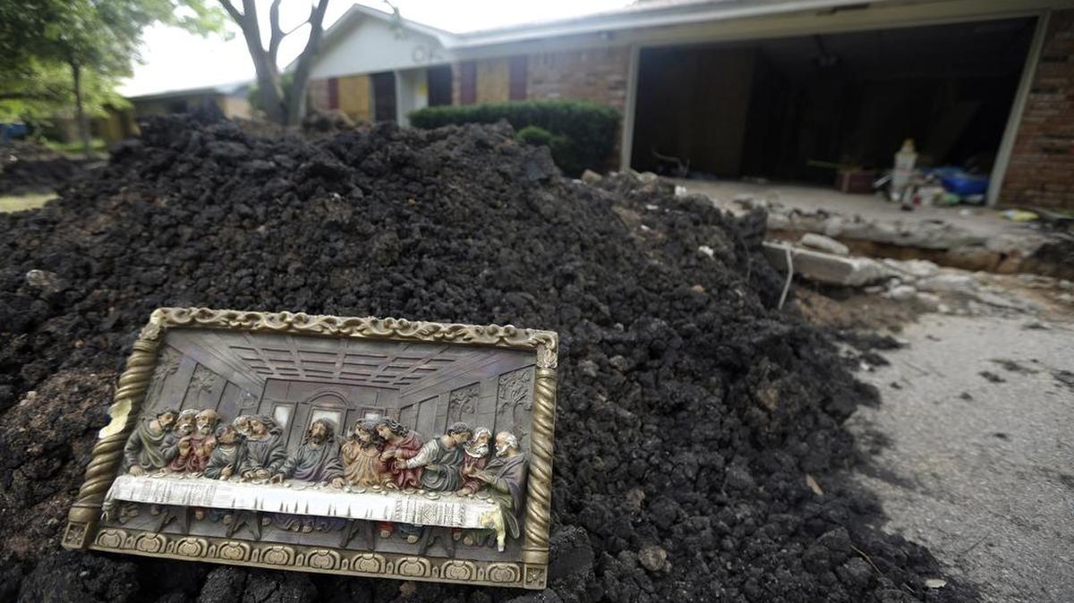 A wall hanging depicting the The Last Supper sits on a pile of dirt Friday, May 31, 2013, in West, Texas, in front of a home severely damaged by the fertilizer plant explosion.