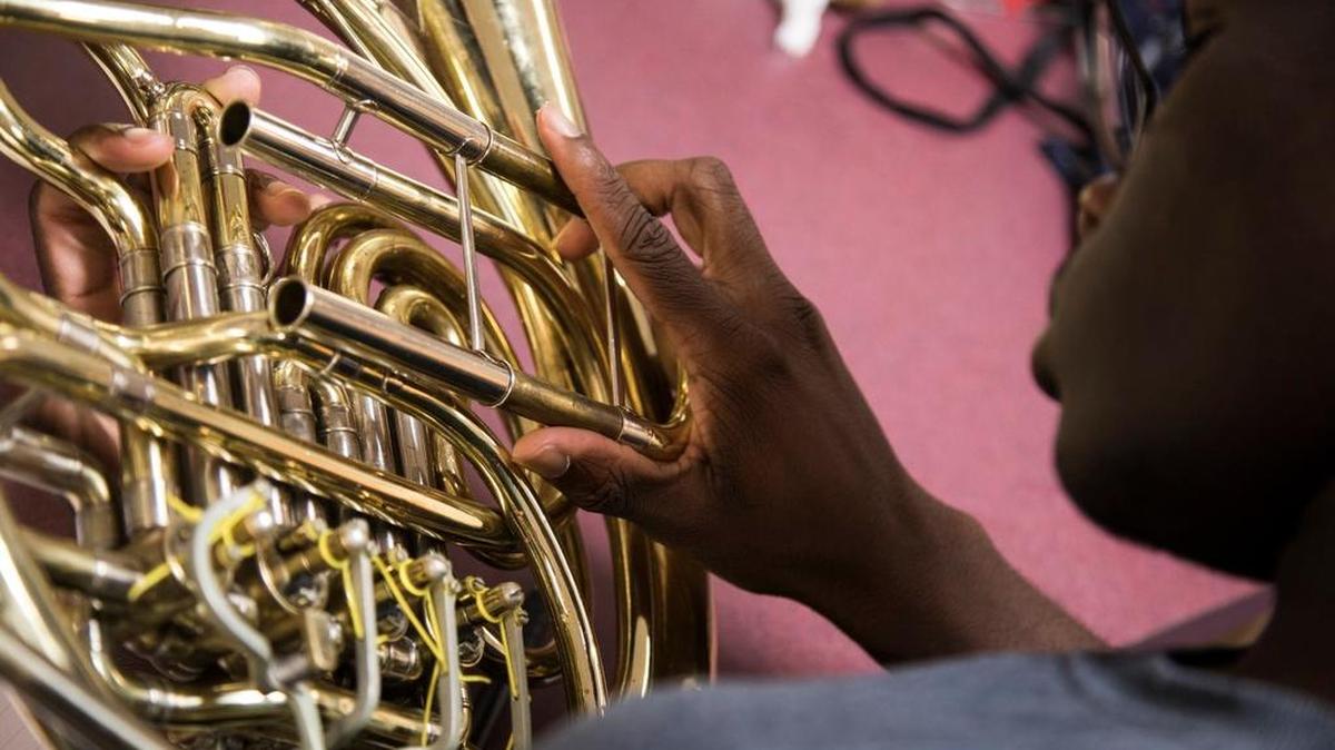 Kevin McCrell reinstalls tubing on a double horn during an instrument repair class at James Bowie High School in Arlington in 2016.