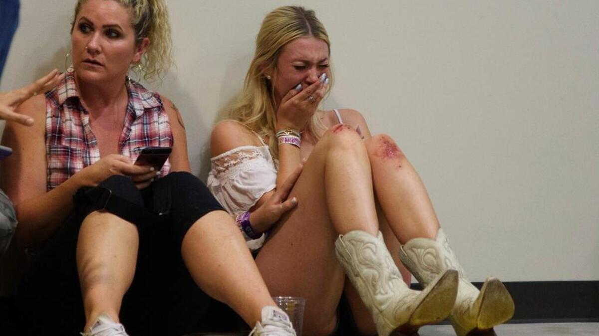 A woman cries while hiding inside the Sands Corporation plane hangar after a mass shooting in which dozens were killed at the Route 91 Harvest country festival on Sunday, Oct. 1, 2017, in Las Vegas.