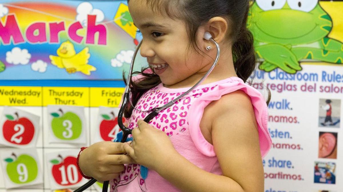 A student at the Gwendolyn C Gragg Child Development Center tries out a stethoscope as she learns about doctors in a lesson plan that investigates student aspirations for the future.