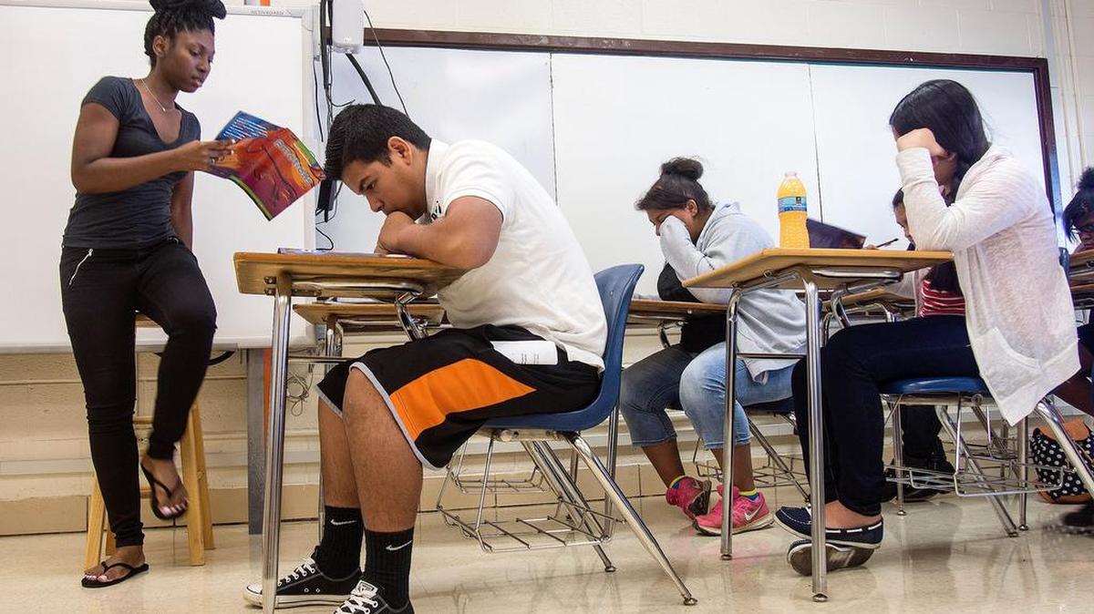 STAAR Camp teacher Nicole Woolridge, left, listens as 7th and 8th grade students read from a text at Meadowbrook Middle School (Fort Worth ISD)in 2015.
