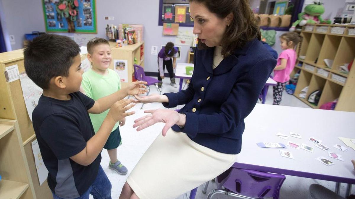 Matthew and Gino give Kara Waddell, president and CEO of Child Care Associates, a high five as they have lessons that investigate their aspirations for the future at the Gwendolyn C Gragg Child Development Center on March 30, 2016.