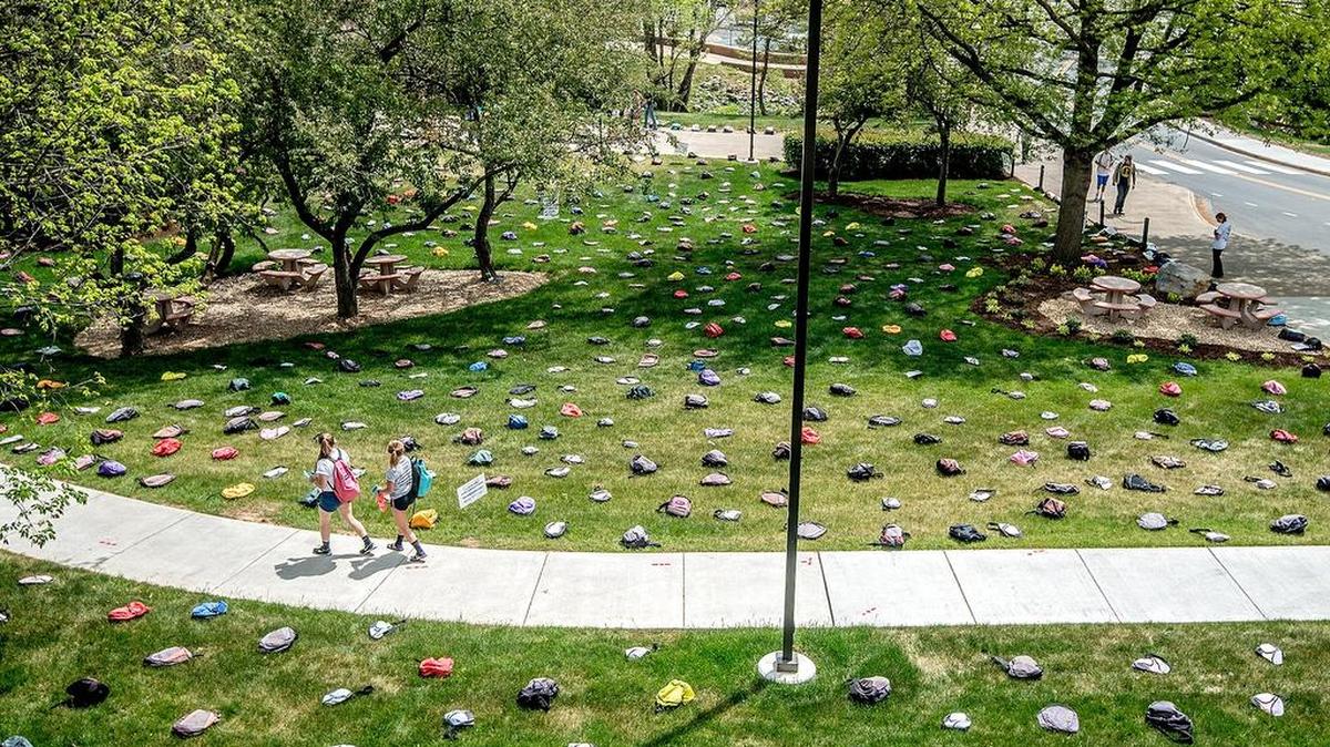 People walk by the Send Silence Packing suicide awareness exhibit on the Madison Union Lawn at James Madison University, Monday, April 25, 2016 in Harrisonburg, Va. The exhibit features 1,100 backpacks to represent the number of college students who commit suicide each year, with personal stories of the lives lost on some of the backpacks.