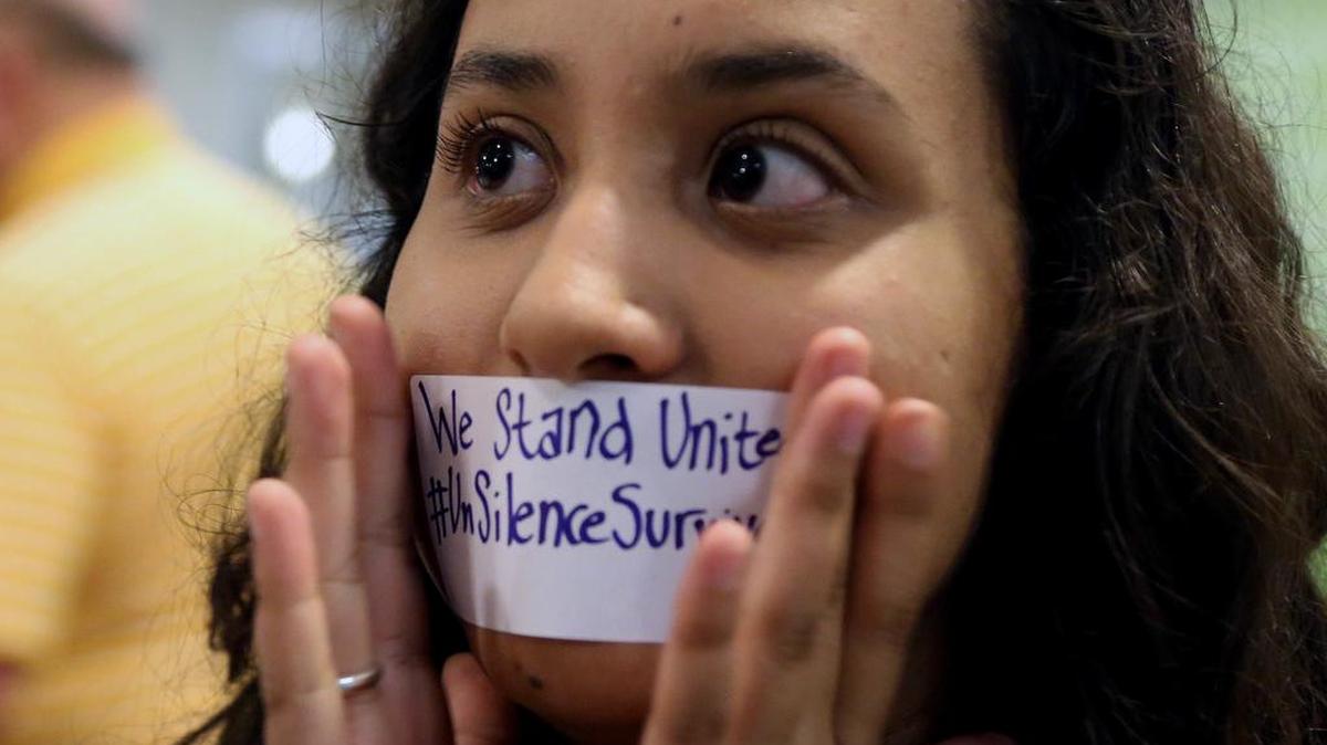 Baylor junior Julieth Reyes cover her mouth with tape during a rally a rally of current and former Baylor students warning of sexually assaults on and off campus, Friday, June 3, 2016, in Waco, Texas. Calling the rally Un-silence the Survivors, they read an open letter to the administration about improvements on how the school should handle sexual assaults after observing a moment of silence.