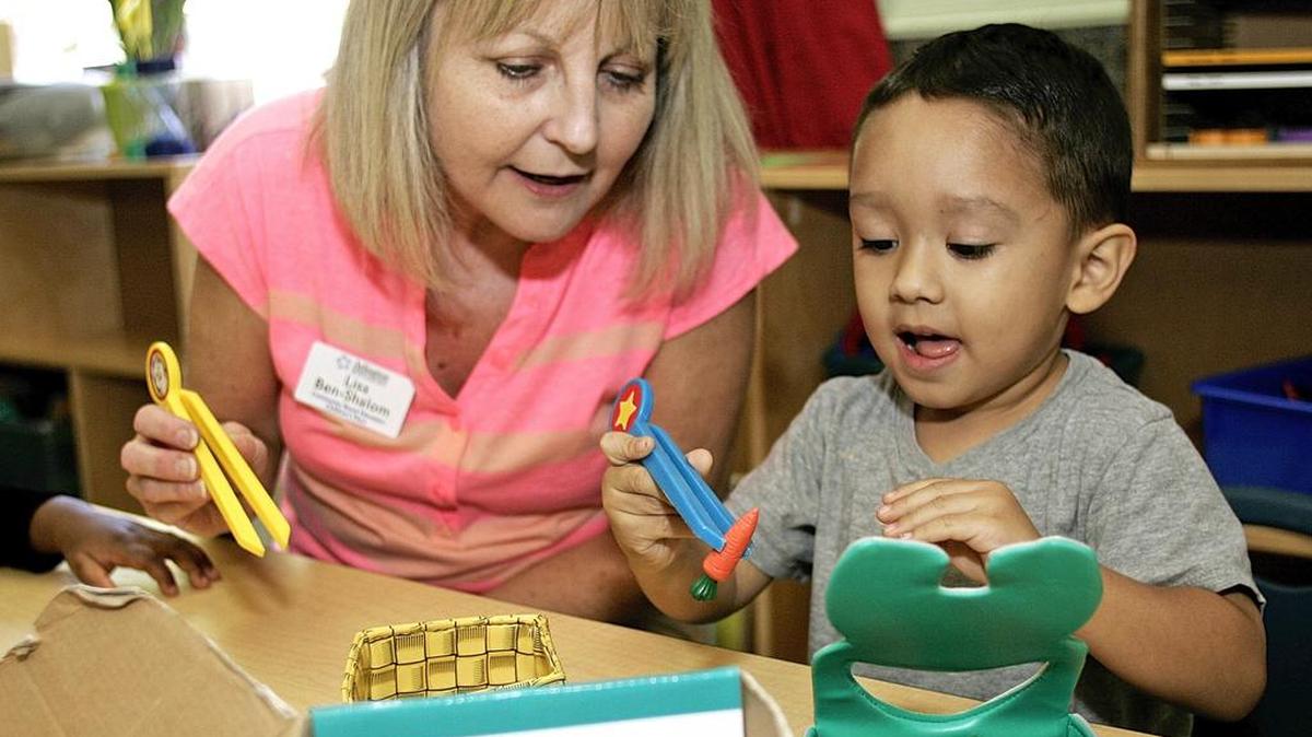 Lisa Ben-Shalom and Allen Martinez play a game and feed carrots to a rabbit box during the morning pre-K class at The Children’s Place in Arlington.