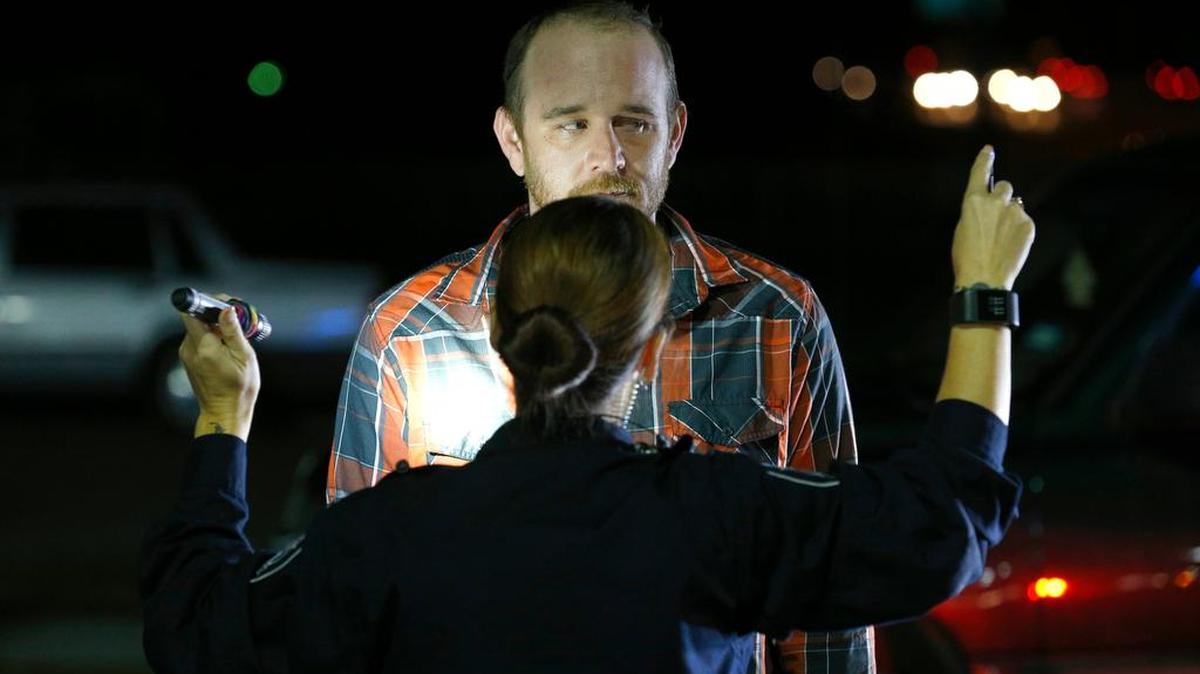 An officer administers a field sobriety test to a driver who was pulled over on suspicion of driving while intoxicated.