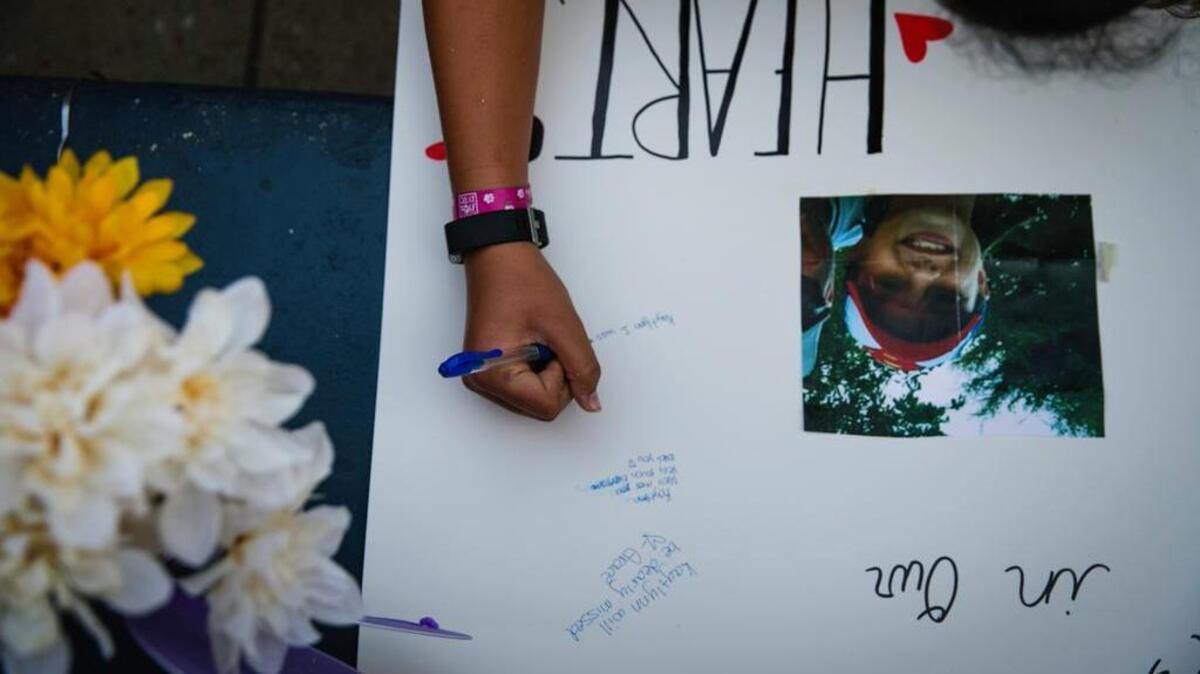 A poster is signed during a prayer vigil in honor of Kaytlynn Cargill at Central Junior High School in Euless, Texas, on Thursday.