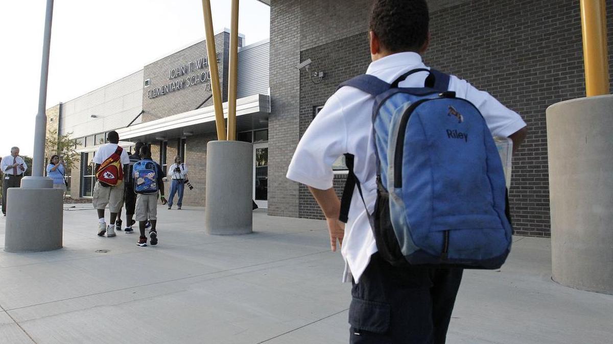 Children and their parents head into John T. White Elementary when the school opened in 2011.