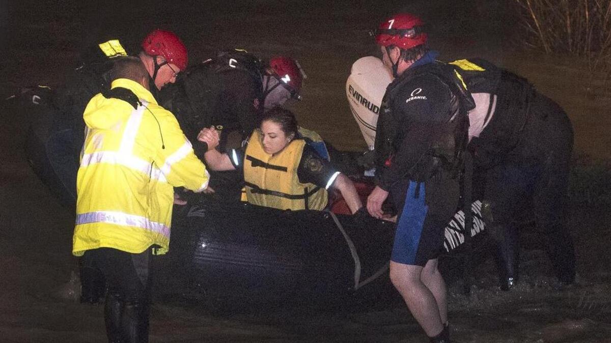 FW firefighter divers assist Sheriffs deputy 26-year old Krystal Salazar from a rescue craft after they rescued her from the raging waters of Deer Creek. Salazar had gone into the water to try and rescue 2 other people that were swept away in the rushing waters. She was taken to an area hospital to be checked out.