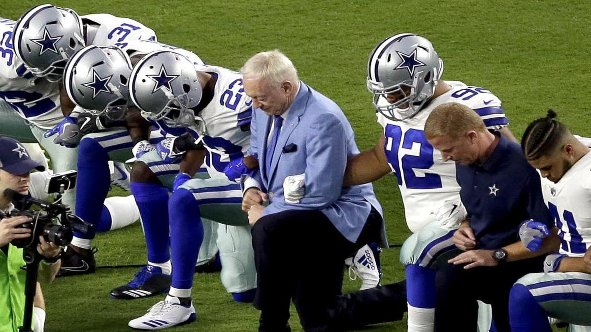 The Dallas Cowboys, led by owner Jerry Jones, center, take a knee prior to the national anthem last month.