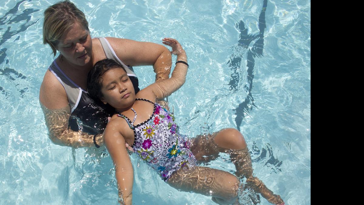 
Volunteer instructor Jennifer Parker helps Giselle Palomo learn drowning prevention in classes at the McDonald YMCA in 2013. 
